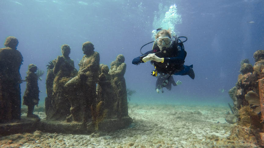 Diving between the statues of MUSA Underwater Museum, Isla Mujeres, Mexico