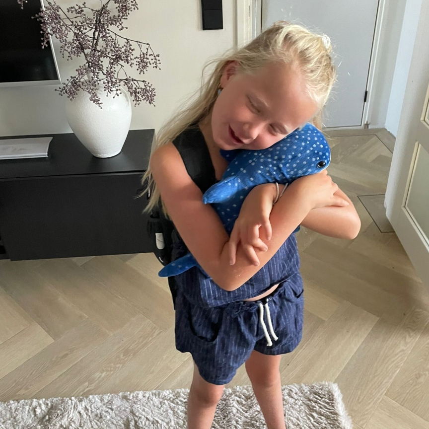 Little girl in love with her whale shark plushie
