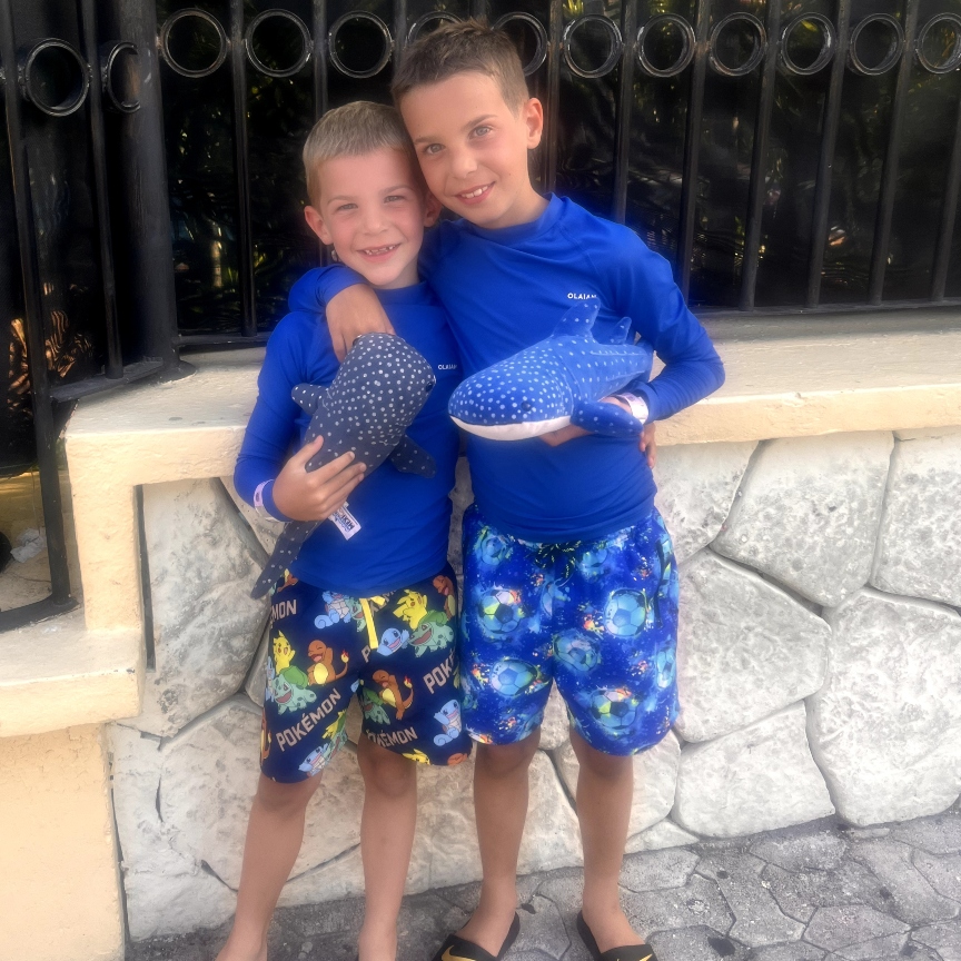 The boys each with a different color whale shark plushie